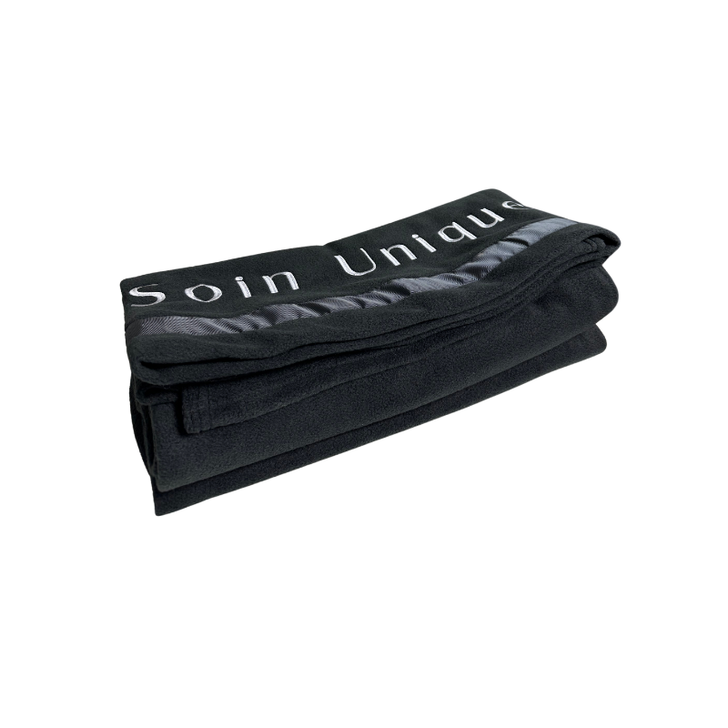 couverture en polar plié noir avec broderie "soin unique"